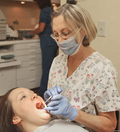 Dental patient getting dental cleaning from a staff member at Dr. Tartaglione's office