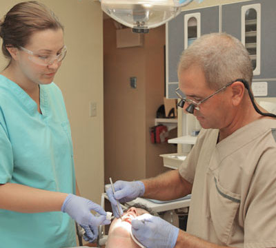 An assistant helps Dr. Tartaglione during a dental procedure.